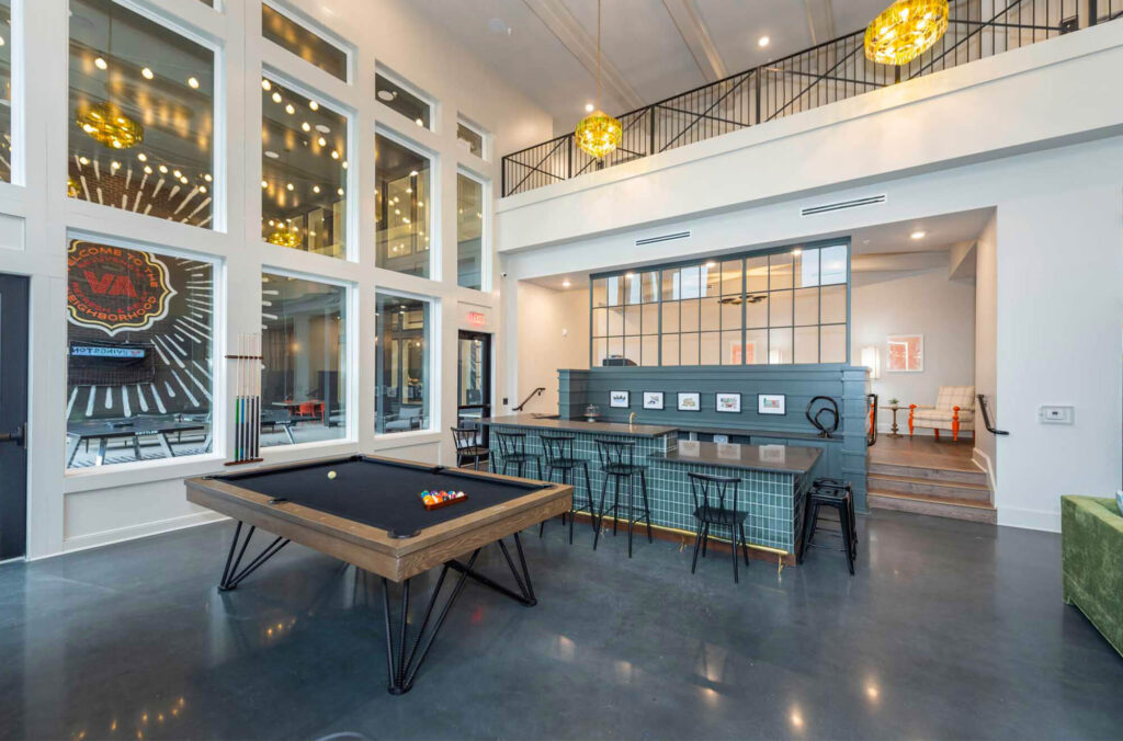 Indoor hangout/game area in Livingston Flats with bar, pool table, and ping pong tables.