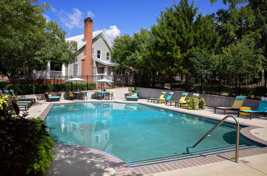 Outdoor view of Riverwatch home and community outdoor pool with high quality furniture.